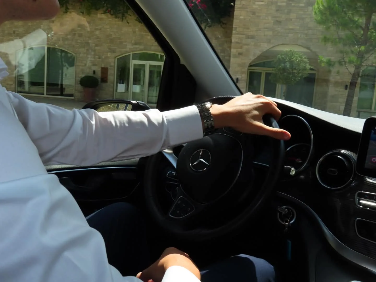 Chauffeur in a white shirt at the wheel of the Mercedes-Benz V-Class